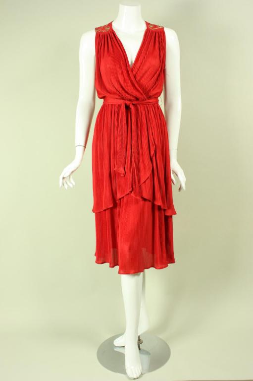 Pleated dress from Radley dates to the 1970's.  It is made of permanently pleated red fabric with rhinestone and gold embroidered detailing at the front and back yoke.  Plunging v-neck.  Unlined.  No closures.

Labeled UK 10, US 8, FR
