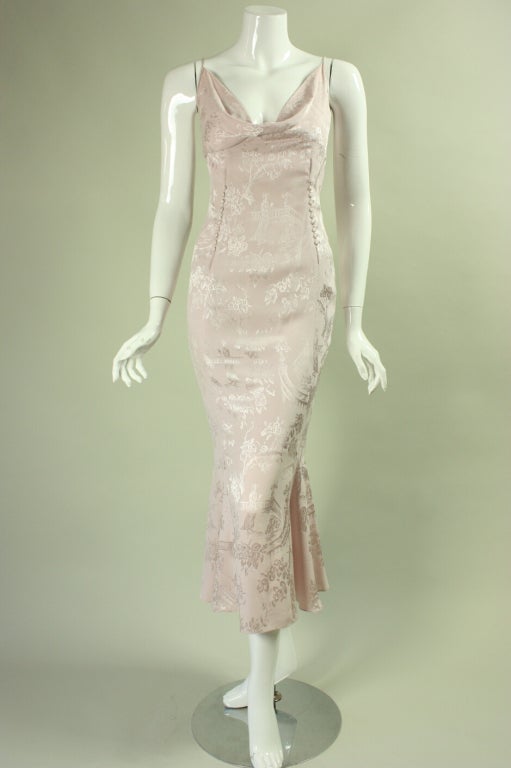 John Galliano cocktail dress is made of pale pink silk charmeuse with an Asian-inspired jacquard weave.  It features four rows of covered buttons through the front and back waist and bells out at the hem.  Side zipper.  Unlined.

Please note that