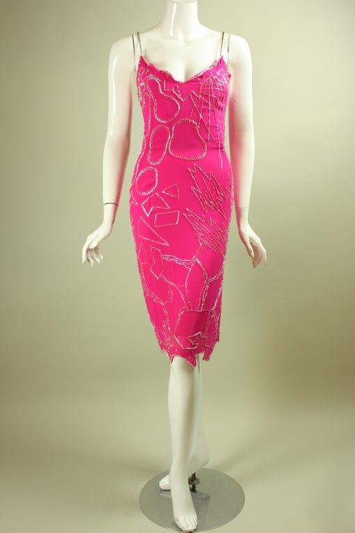Vintage dress from Haitian-born designer Fabrice is made of hot pink silk with allover beading in an abstract pattern.  Fitted dress has rhinestone spaghetti straps, v-neck, and handkerchief hem.  Center back zipper.  Dress is lined.  Shawl is not.
