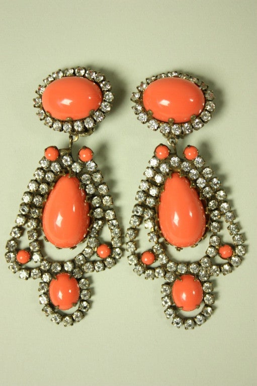 Vintage Kenneth J. Lane dangle earrings feature prong-set rhinestones that encircle coral-colored cabochons.  Clip back.  Signed KJL on the clips.
  
Measurements-
Length: 3 3/8