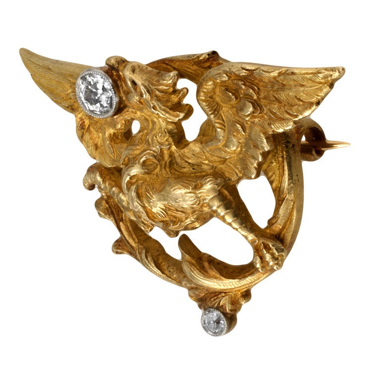 Art Nouveau Diamond & Gold Griffin Brooch, Circa 1905
A beautiful patina accentuates intricate details on both, front and back sides, set with two old European cut diamonds totaling approximately 0.33 carat