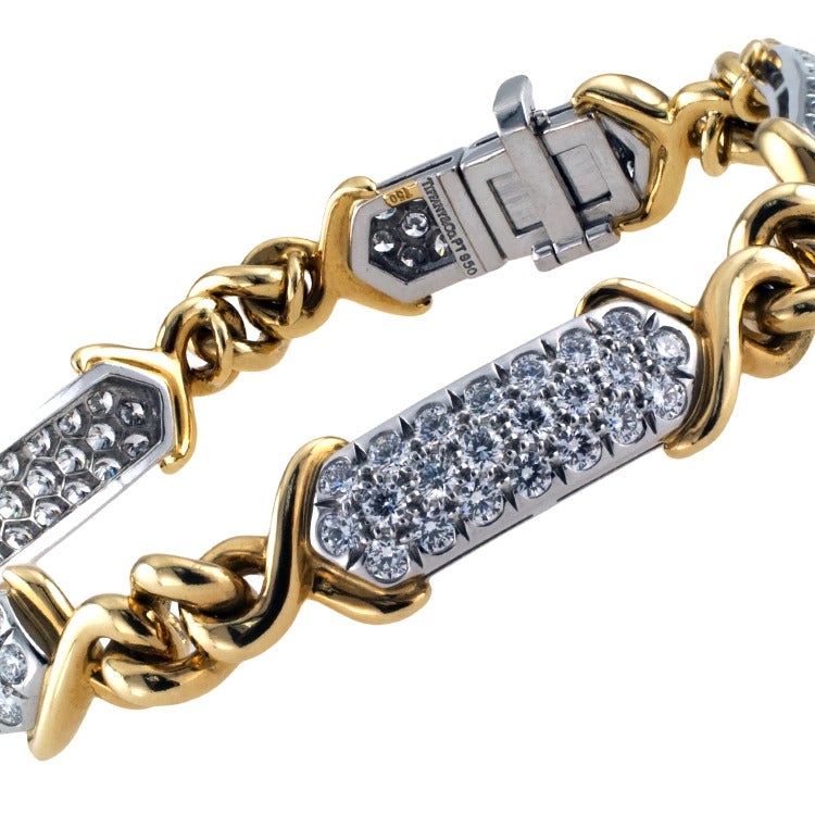 This beautiful bracelet is designed as a series of five rectangular platinum and diamond plaques connected by bright, knotted 18 karat gold links, the diamonds totaling approximately 4.50 carats, approximately E - F color and VS clarity, 10 mm. wide