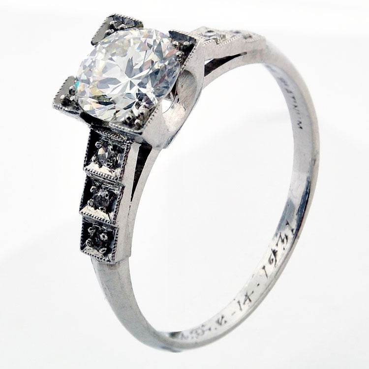 An Art Deco Diamond Engagement Ring, Circa 1931
The center diamond is an old Transitional cut diamond weighing approximately 1.07ct. ( approximately VS2, H color).  It has never been removed from the ring.
The geometric designed platinum ring