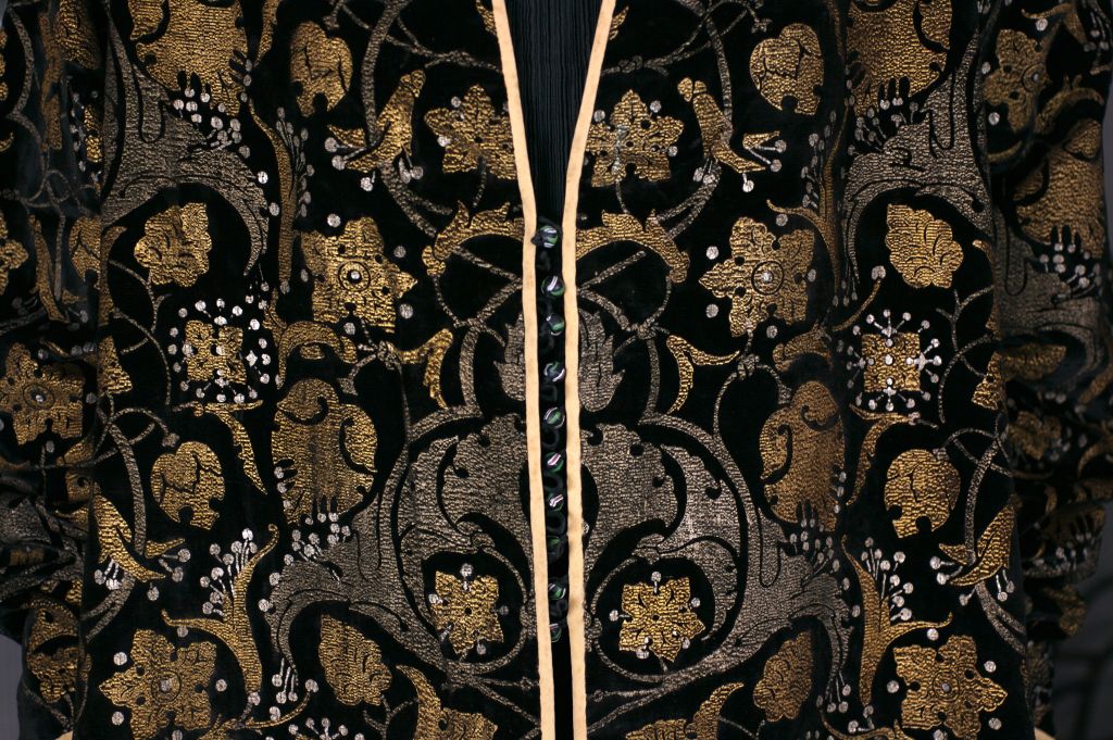 This three-quarter length black  velvet persian  coat was printed with metallic paints with Venetian glass buttons and silk loop closures at the center front.

The hand stenciling is done with real gold metallic pigments aged to a mellow,