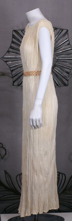 This extraordinarily rare dress is made of finely pleated  white cotton. Few cotton pleated Fortuny dresses have been documented and survived.<br />
<br />
Named after a Greek classical sculpture, the Delphos Gown was a simple column of vertical