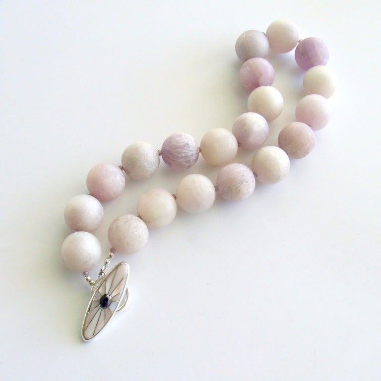 Kunzite gumball sized beads in the sweet confectionary color of the year, Radiant Orchid, create a modern and feminine choker necklace.  The untamed nature of these matte finished beads is a sophisticated juxtaposition when paired with the delicate