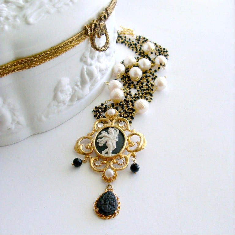 A classic black and white Venetian intaglio cameo angel pendant, embellished with a gold vermeil cartouche setting, moonstones and freshwater pearls has been paired with a delicate 5 strand torsade of black spinel and freshwater baroque pearls. This