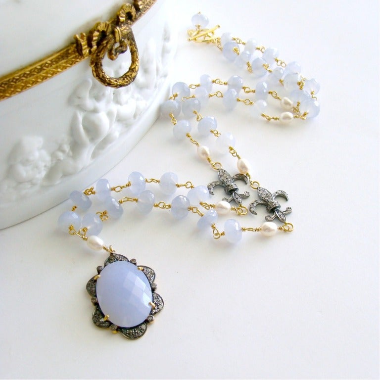 A gorgeous hand linked beaded chain of periwinkle blue chalcedony intercepted with creamy ivory pearls and cheeky little pave diamond Fleur de Lis accents - presents a stunning summer necklace in a powdery pastel palette.  A sinewy pave diamond