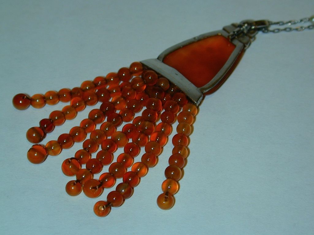 Art Deco platinum and agate drop pendant consisting of a flat urn-shaped orange agate upper section accented with rose cut diamonds and suspending 9 orange agate bead tassels on original 34” long platinum and natural pearl chain.  French hallmarks.