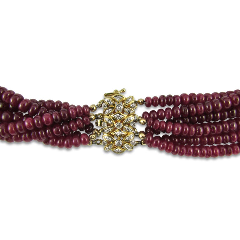 Six strand ruby bead necklace of rondelle-shaped tumbled beads strung on an 14KT yellow gold and diamond clasp. Ruby weight is approximately 900 carats. Rubies are treated.