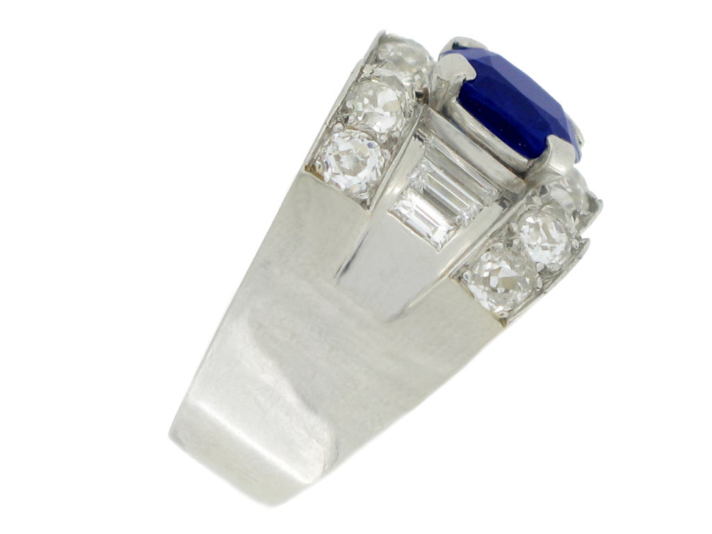 Sapphire and diamond ring by Mauboussin. Set to centre with a natural unenhanced cushion shape old cut sapphire in an open back four claw setting with an approximate weight of 3.00 carats, flanked by six channel set rectangle baguette cut diamonds