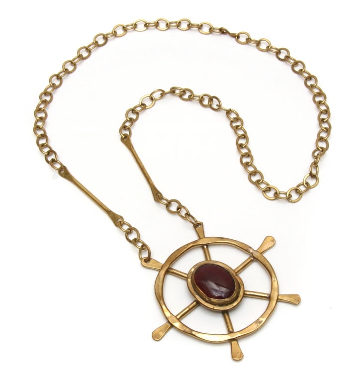 Signed Rafael gold toned necklace with ship's wheel pendant and large purple glass cabochon.