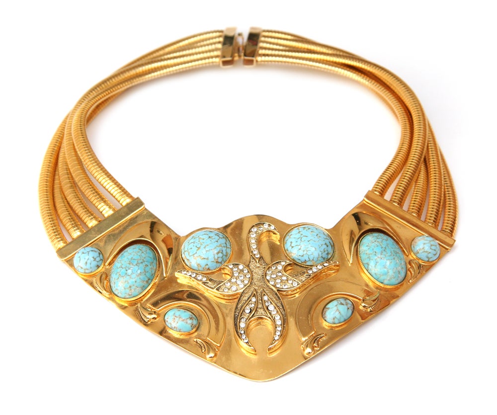 Hard gold toned metal bib necklace with turquoise cabochons and snake chain.