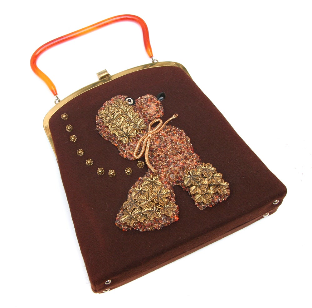 Souré Bag of beaded poodle on felt with glass eye and orange lucite handle. This purse is a true collectable!