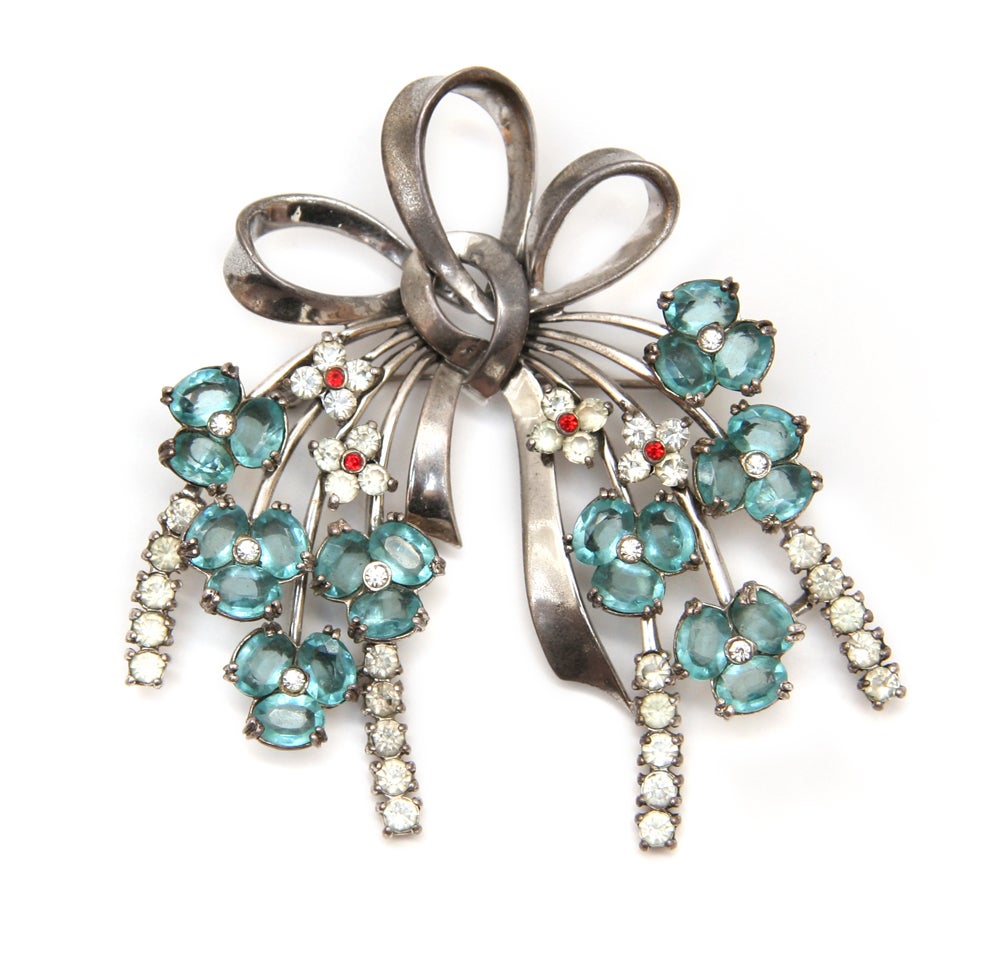 Peninno bow pin with clear and aqua crystals set in Sterling Silver.