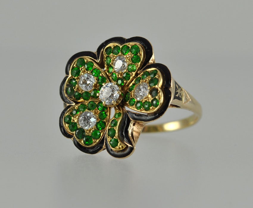 Victorian 4 leaf clover ring with black enamel, demantoid garnets and 0.75 carats of Old European cut diamonds. The ring is circa 1900.