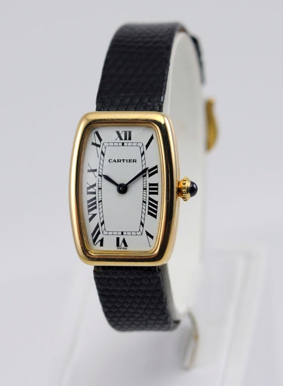 Chic Cartier ladies watch in 18k yellow gold.  Manual wind movement.  <br />
The buckle is a gold filled replacement buckle.