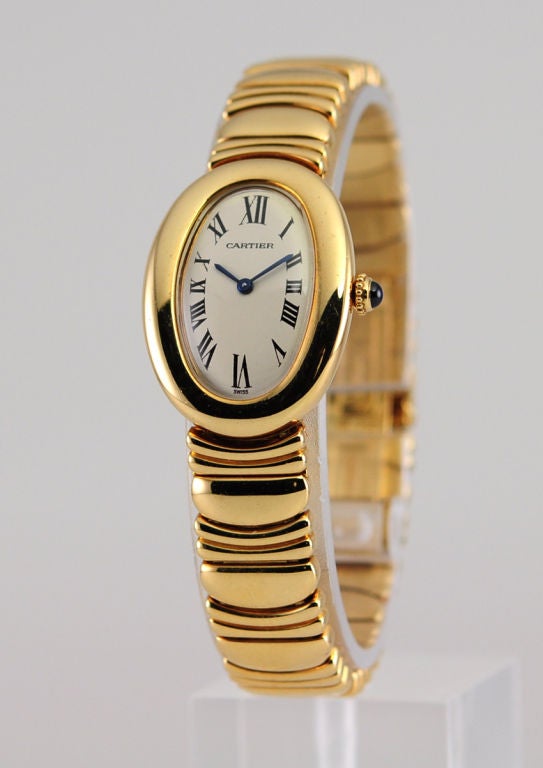 Gorgeous Cartier ladies Baignoire watch. Roman numerals on an elongated oval dial. This ever popular ladies Baignoire step-case watch is of 18karat yellow gold. It is attached to an 18karat yellow gold Casque d'or bracelet with deployant buckle. The