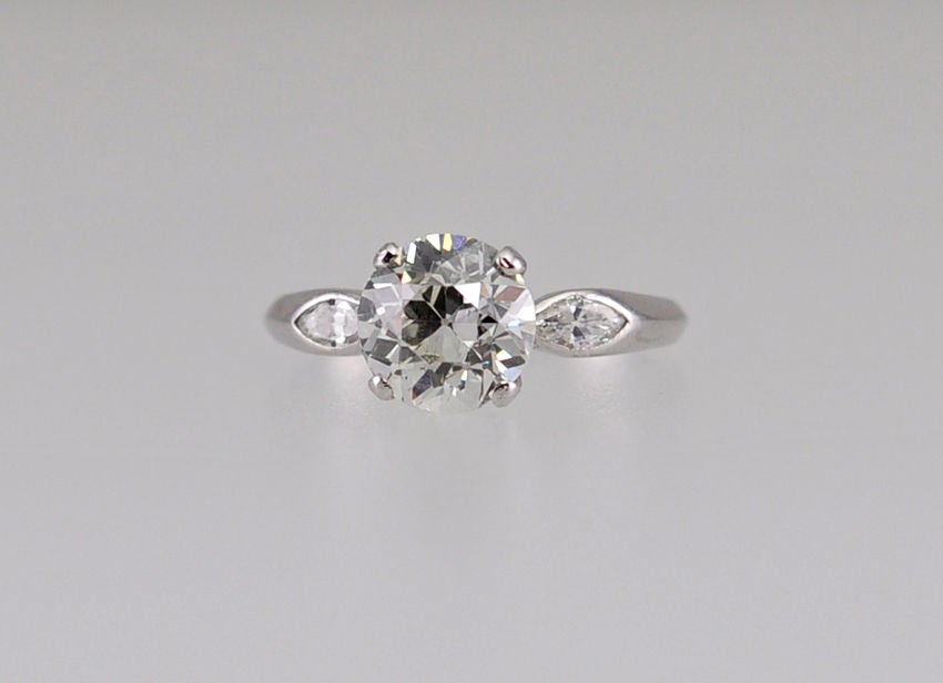Platinum ring with center prong set  old european cut diamond equaling 2.01ct I-SI2 EGL cert.  On each side are a bezel set marquise diamond.  This ring has a simple elegance...