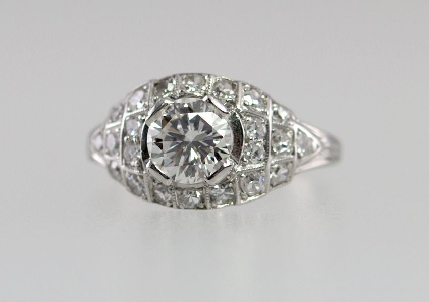 Art Deco diamond and platinum ring from circa 1930s.  This pretty ring features a 0.80 Old European Cut diamond that is H-I in color and SI2 in clarity.  The center stone is surrounded by 22 single cut round diamonds in with a slight step mounting. 