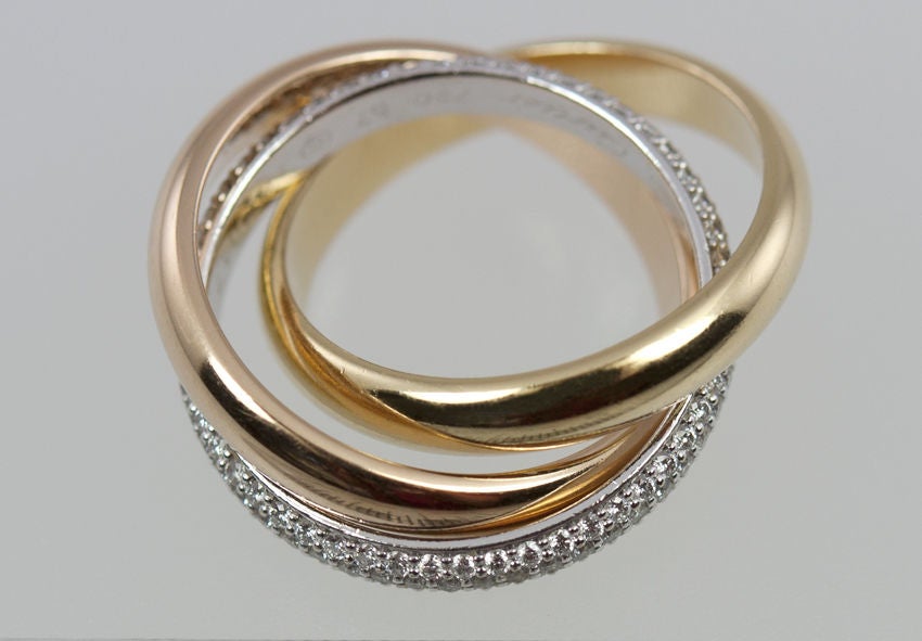 Your Love is forever in this Cartier Trinity ring. Such a classic! With a pink gold,yellow gold,and white gold band which is paved with diamonds. All 18k, size 8 and we have the Cartier papers for this band. Retail on this rolling band at Cartier is