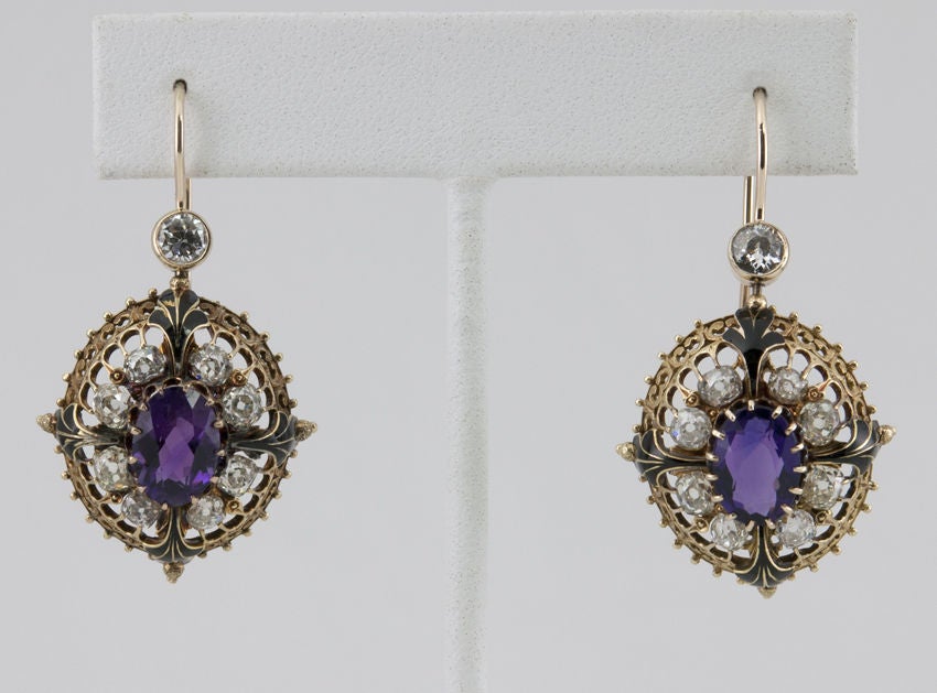 These are very beautiful victorian earrings, with center amethysts with great color, surrounded by old cushion cut diamonds equaling 3cts total. There are also black enamel details. Very Victorian!
