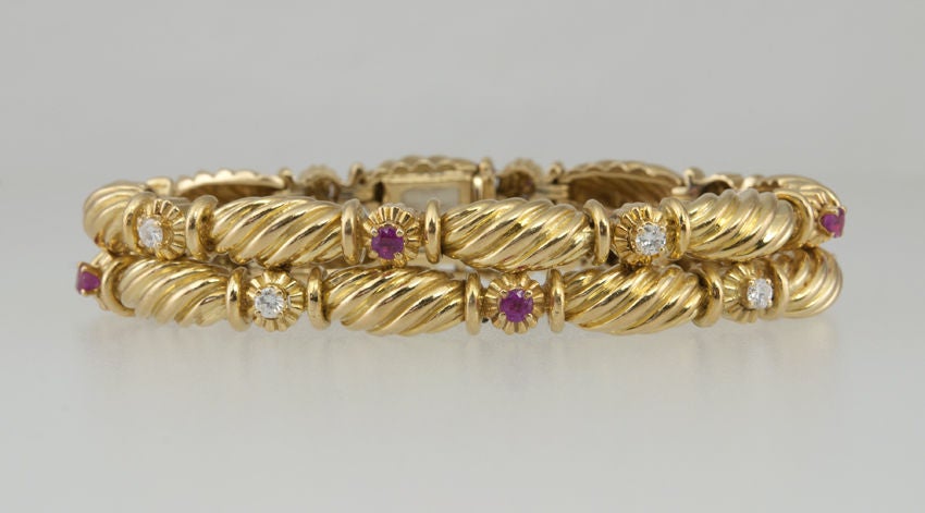 Tiffany & Co 18 karat yellow gold double row bracelet with a twist design with alternating 8 brilliant cut round diamonds and 8 brilliant cut round rubies. The diamond weight is approximately 0.80 carats.  Circa 1990s. Very stylish and