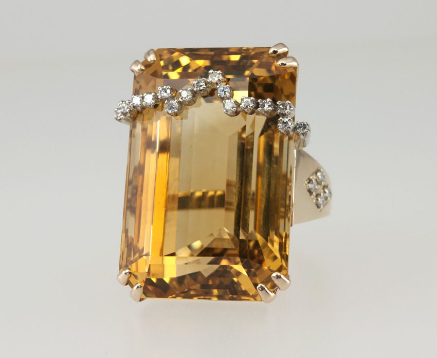 This reminds me of the jewelry my grandmother wore, big,chunky,statement pieces that everyone wore after the war.  This is a faceted golden yellow citrine weighing a whopping 100 cts!  The mounting has four full cut diamonds in a triangle on each