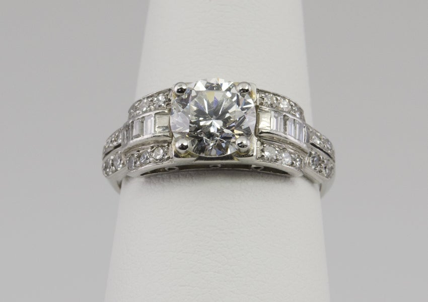 Platinum ring with center 1.20ct diamond H-VS2 with an EGL certificate. The sides have three rows, a center row of baguette diamonds, bordered with a line of single cuts. Then it descends to two rows of single cuts.