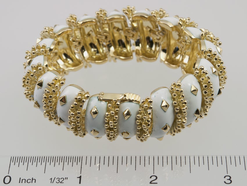 David Webb 18 karat yellow gold link bracelet from circa 1970.  It has alternating studded gold links and white enamel with three gold pyramids shapes.  Very Chic!

This bracelet measures approximately 6.5 inches in diameter, 0.91 inches in width,
