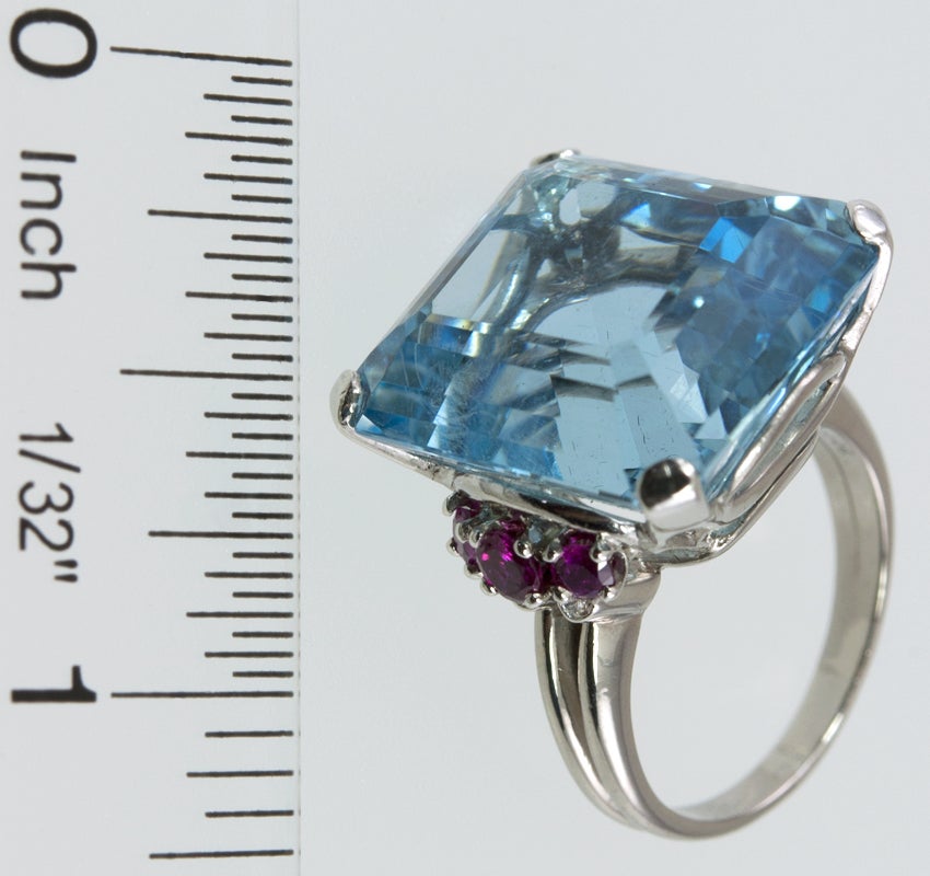 This stunning ring has a center 28.5 carat square cut Aquamarine in a beautiful platinum mounting. On each side there are three rubies and two bezel set full cut diamonds, that add that touch of pizazz!!  Oh...and it