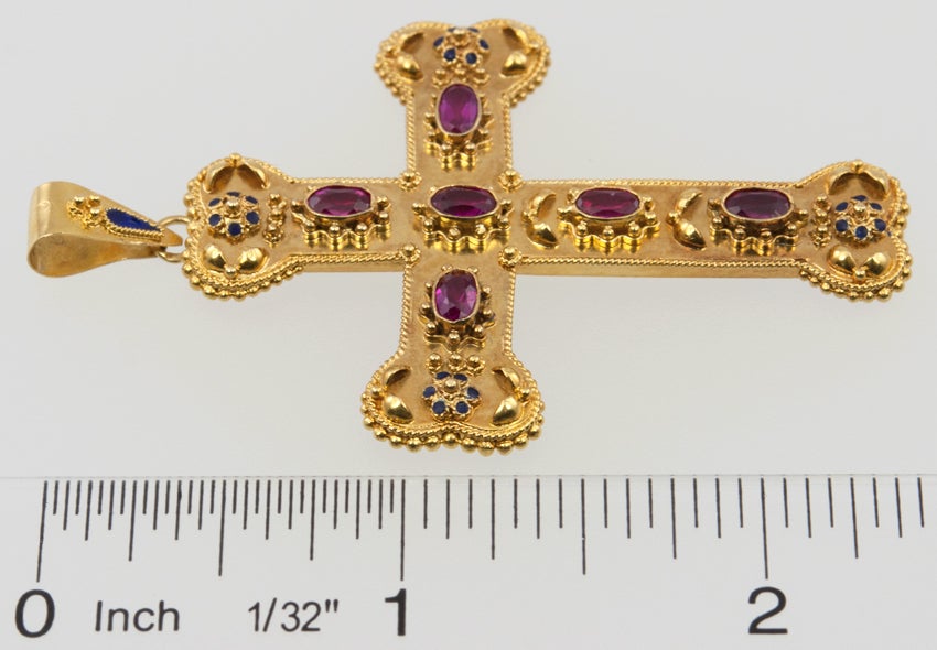 18k Estruscan revival cross pendant from the Victorian era.  The rubies are synthetic, which they started doing in the late 1800's. There are accents of blue enamel on all the little flowers.