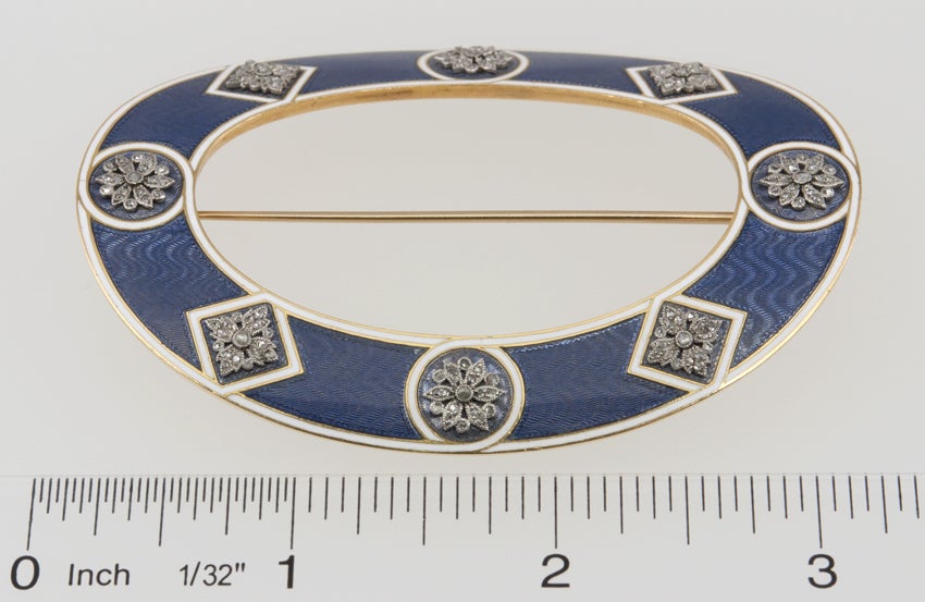 Large oval 18k gold brooch,with an open center and gorgeous light blue gouache enamel work. White enamel forms borders for eight intricate platinum rose cut diamond "snowflakes"

A Cartier large oval brooch in 18 karat yellow gold and