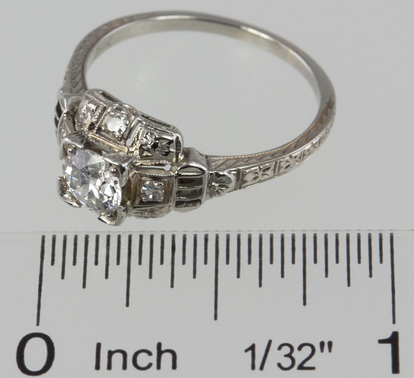This 18k white gold ring has the box set diamond step motif that has that very Deco feel.  The center old european cut diamond is .55 carat H-I SI1. Really lovely ring.