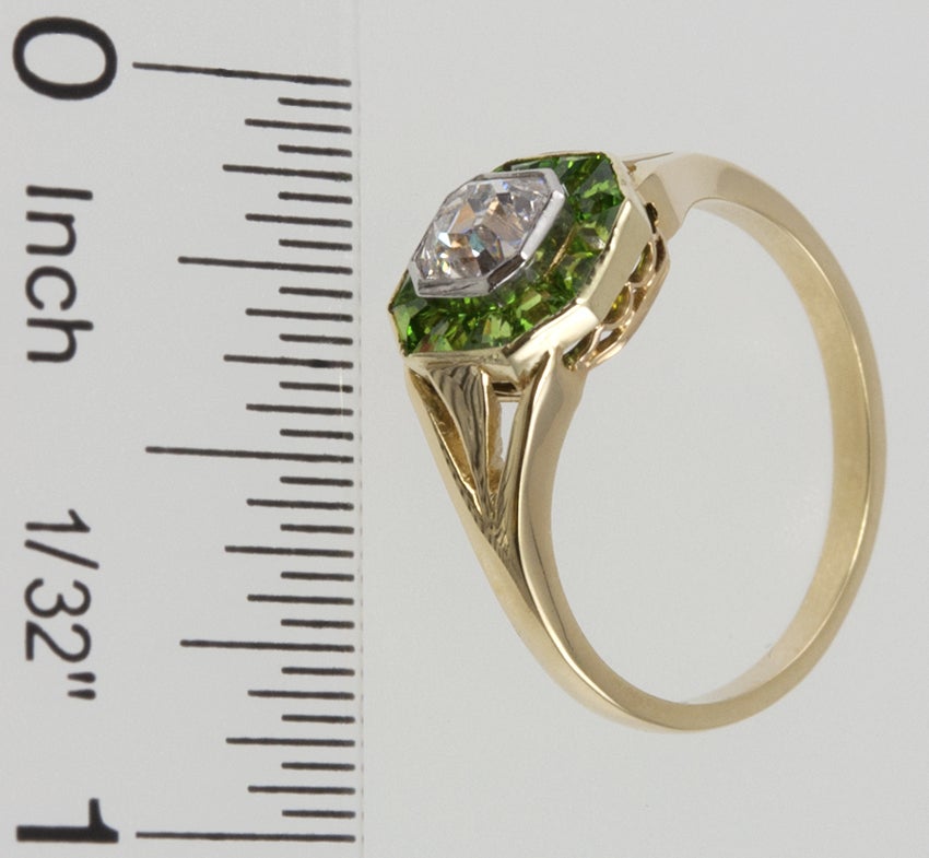 18k yellow gold simple ring with a channel of faceted demantoid garnets around a center old antique emerald cut, or asscher cut set in a platinum bezel. The diamond is approximately 0.75 carats G-VS1.