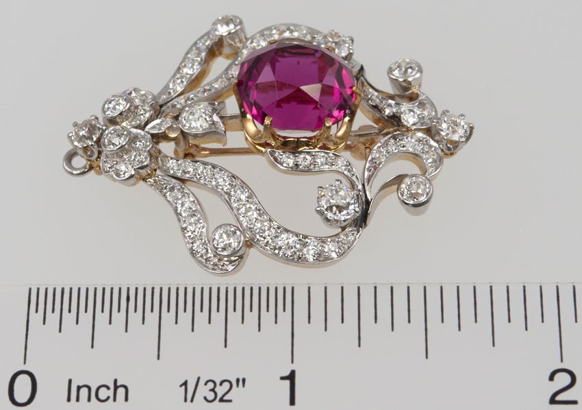 Platinum TIFFANY & CO brooch filled with old european cut diamonds and a center dark pink tourmaline weighing approximately 8.50 carats.  The basket of the tourmaline and the back of the brooch are 18k yellow gold. It also has a fold down bale to