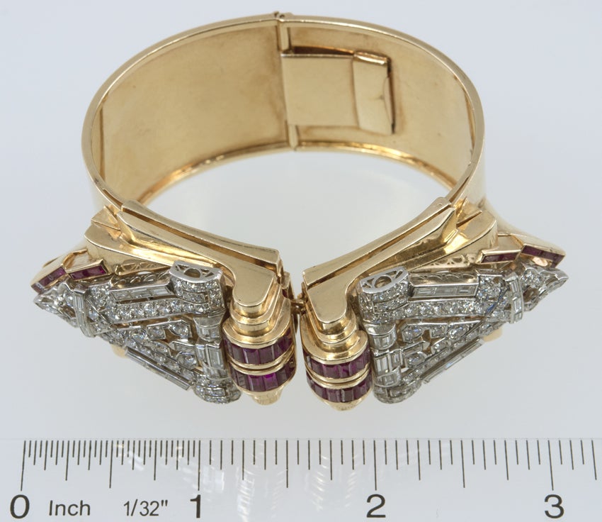 Wide bangle bracelet with a hinged back for easy opening, that holds in the front two retro dress clips which hold platinum Deco clips!.  The clips have 4.25 carats of single, full and baguette cut diamonds, that attach to a retro clip that includes