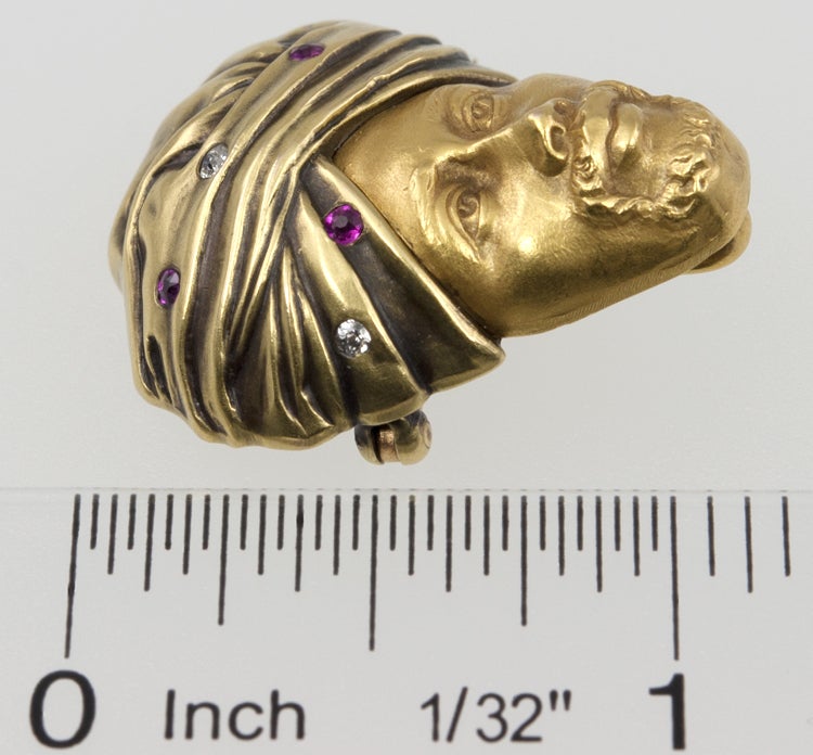 14k gold turban man pin, with  turban filled with four full cut old european diamonds and three rubies.  He also has a hook that was used to hang a pocket watch.  He is very distinguished , a real collector's piece.