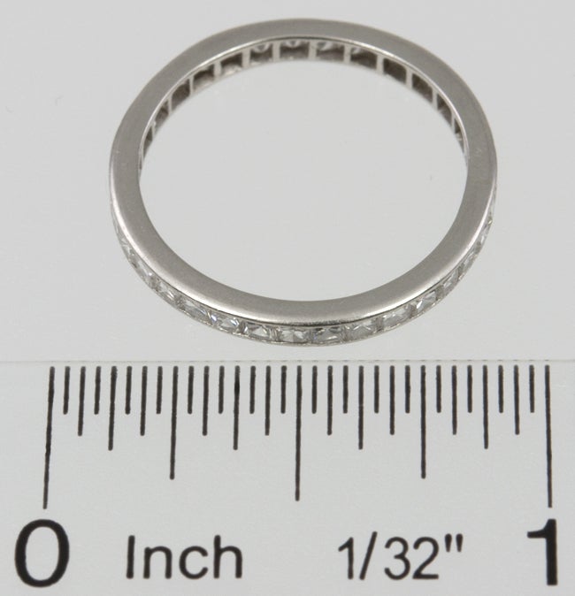 Platinum band with 33 channel set french cut diamonds, with one baguette diamond, that was probably used for sizing at one time, since french cut damonds are rare and hard to find ( shown in thumbnail photo)  The total diamond weight is 1.75cts and