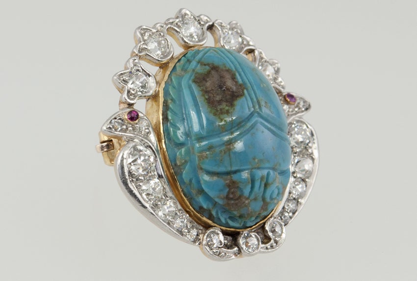 Man! They were crazy about everything Egyptian around the turn of the 20th century! Platinum top, gold back on this turquoise scarab brooch.  It is surrounded by a lotus blossom design, embellished with diamonds, and two small accent rubies.
Really