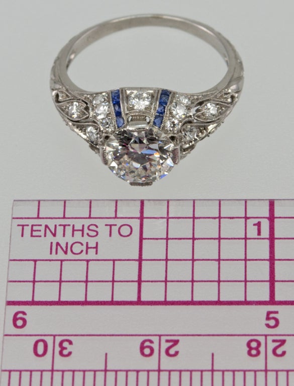 Beautiful, elegant ring!  This ring has very decorative filagree cut out work, that is diamond encrusted with full and single cut diamonds.  The center old european cut diamond is 1.24 carats G-Vs2 with an EGL certificate. There are four channels of