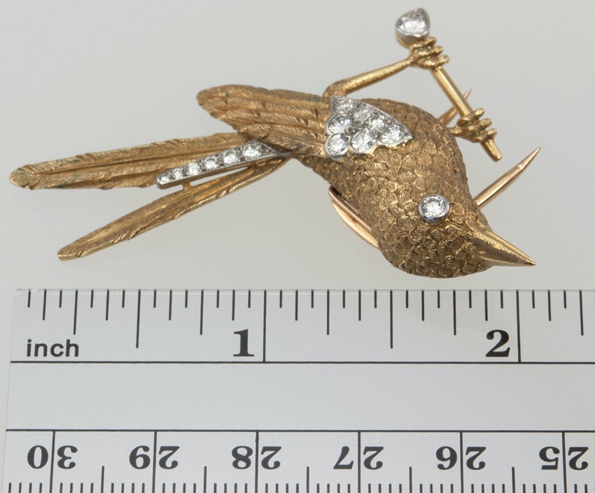 18k yellow gold CARTIER bird pin with round brilliant diamond accents.  The gold has a florentine finish, a really gorgeous texture,  This is a really special piece.