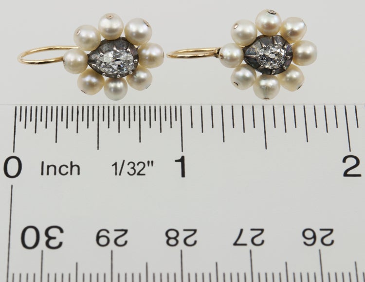 Silver and Gold pearl cluster earrings with a center old cut pear shape in each, approximately .50ct and .30ct each. Each is surrounded by eight silver/grey pearls, believed to be natural.