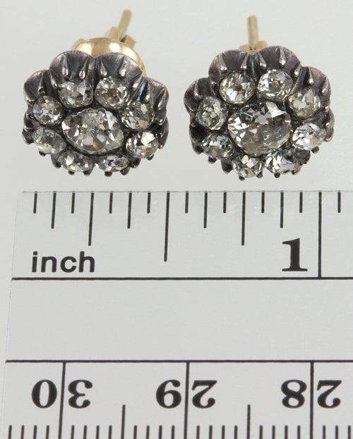 Silver top and gold back cluster earrings filled with approximately 3 carats of really old cushion cut diamonds, with a .60ct cushion cut in the center.