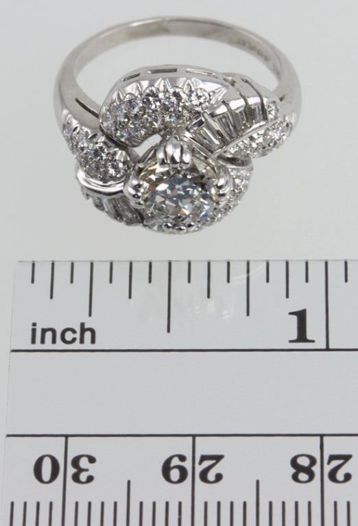 Platinum cluster ring with center 1.04 carat diamond M-VS1 with an EGL certificate. There is another  approximately 2.50 carats of small full cuts and tapered baguette diamonds, making this a very blingy ring!