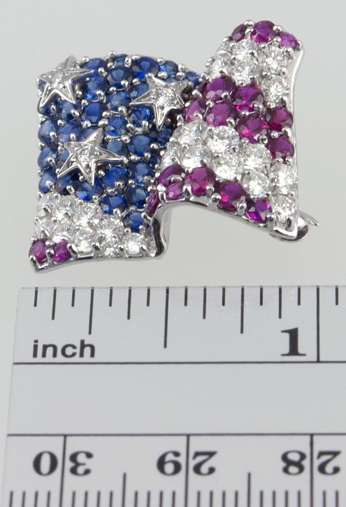 18k white gold waving american flag pin with diamonds,sapphires and rubies.