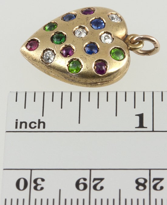 14k yellow Victorian gold heart locket filled with colored gems! There are 4 old cut diamonds, four old cut demantoid garnets, four old old rubies, and three old cut sapphires. Unusual and charming.
