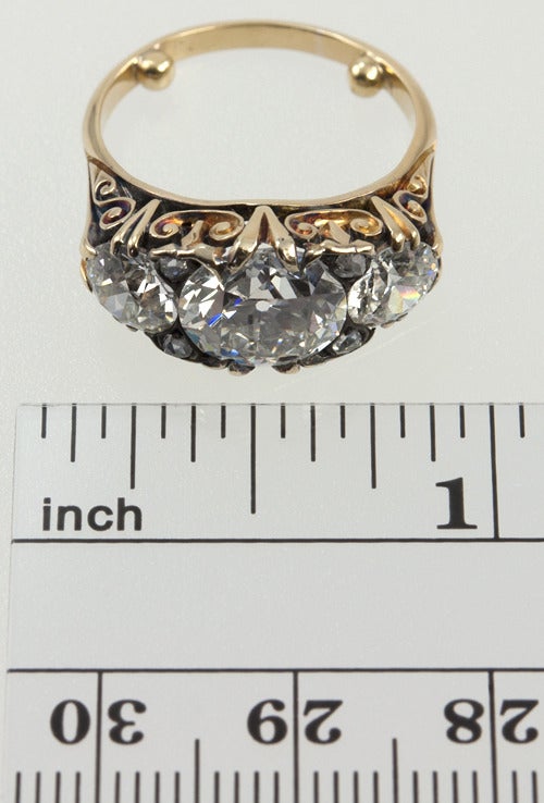 18k yellow gold ring with a very ornate curly gallery, and three old european cut diamonds across the top.  The center is 2.72ct H-VS1 with a GIA certificate. The two diamonds on either side are .75 cts and approximately the same quality as the