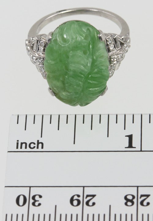 This beautiful platinum ring has a center panel of jade carved and perforated into a graceful leaf pattern.  The sides are pure Deco filled with single cut diamonds.
The ring is size 6 1/2 and can be easily altered.