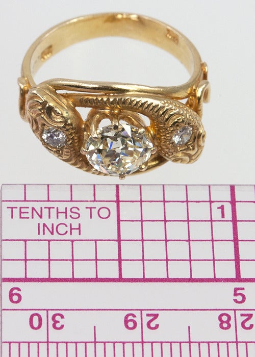 18k yellow gold Victorian double headed snake ring.  There is a full cut diamond in each head, wrapping around a large approximately 1.60 carat old european cut diamond, approximately L-M color, and SI1 clarity in the center.  This ring is a